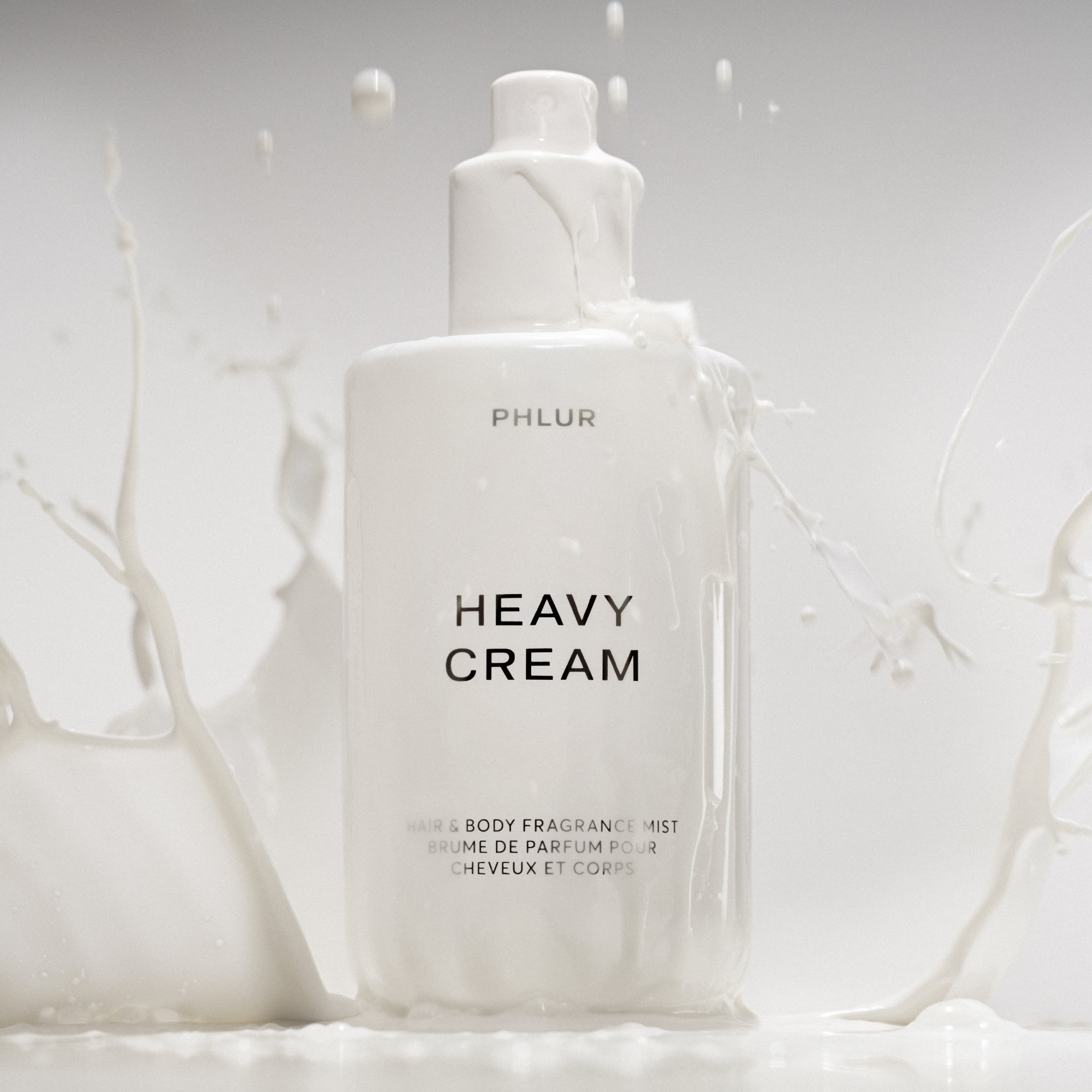 Phlur Heavy Cream body mist bottle in a milk splash